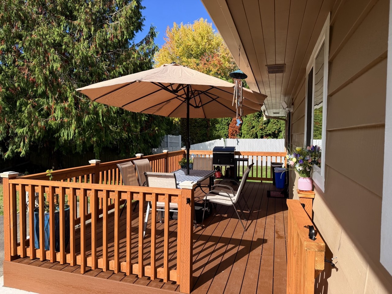 Shaded outdoor deck with patio table overlooking garden